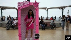 Una manifestante antigubernamental en Perú disfrazada de "Barbie Dictadora" sostiene un fusil de asalto de juguete durante una protesta contra la presidenta Dina Boluarte en Lima el 22 de julio de 2023.