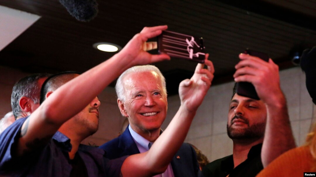 Democratic presidential candidate and former Vice President Joe Biden takes selfies with customers at Roscoe's Chicken and Waffles as he campaigns before his evening rally on Super Tuesday in Los Angeles, Calif., March 3, 2020.