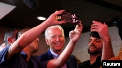 Democratic presidential candidate and former Vice President Joe Biden takes selfies with customers at Roscoe's Chicken and Waffles as he campaigns before his evening rally on Super Tuesday in Los Angeles, Calif., March 3, 2020.