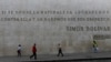 La gente pasa por delante de un mural en piedra con frases de Simón Bolívar cerca de la Asamblea Nacional de Venezuela en Caracas, en enero de 2020.