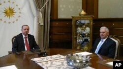 Turkey's President Recep Tayyip Erdogan, left, meets with Turkey's Prime Minister Bibali Yildirim, right, in Ankara, July 19, 2017. (Presidency Press Service via AP, Pool)