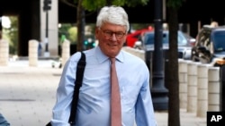 Greg Craig, right, former White House counsel to former President Barack Obama, walks into a federal courthouse for his trial, in Washington, Aug. 22, 2019. 
