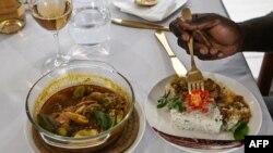 A customer eats rabbit gouagouassou sauce accompanied by rice, made by Ivorian chef Charlie Koffi, at the Villa Alfira restaurant in Abidjan on December 4, 2023.