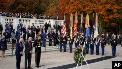 President Joe Biden stands with Veterans Affairs Secretary Denis McDonough and Army Maj. Gen. Allan M. Pepin during a wreath laying ceremony to commemorate Veterans Day and mark the centennial anniversary of the Tomb of the Unknown Soldier at Arlington National Cemetery in Arlington, Virginia.
