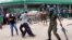 A police officer fires pepper spray at supporters of the opposition United Party for National Development outside the Woodlands Police Station in Lusaka, March 2, 2016. 