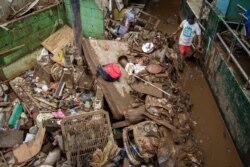 Warga berusaha membersihkan lumpur pasca banjir di Jakarta, 3 Januari 2020 (Foto: Antara/Reuters).