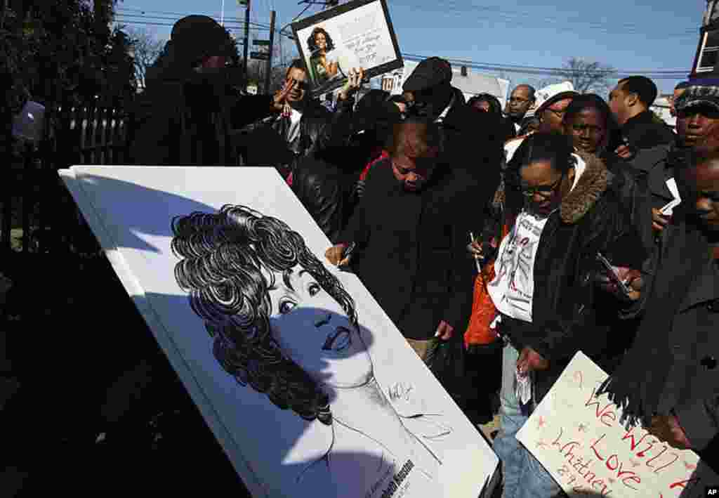 惠特尼.休斯顿的歌迷们在离她的葬礼会场几个街区的地方签署一张悼念卡