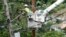 FILE - A worker from the Cobra Energy Company, contracted by the Army Corps of Engineers, installs power lines in the Barrio Martorel area of Yabucoa, Puerto Rico, May 16, 2018.