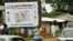 People walk in front of posters for the presidential elections and instructions on the voting card, Conakry, 25 Jun 2010