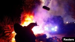 Centenares de ucranianos salieron a las calles de la ciudad de Novi Sanzhary, en la región de Poltava, para protestar con violencia la llegada de evacuados de China. Los evauados permanecerán durante dos semanas en cuarentena en un hospital local. Foto Reuters