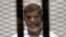 FILE - Ousted Egyptian President Mohamed Morsi is seen behind bars during his trial at a court in Cairo May 8, 2014.