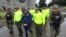This undated photo released by Colombia's National Police shows officers escorting a man whom police identified as Ecuadorean drug trafficker Edison Prado after his April 2017 arrest on an indictment by a Florida federal court. A few months after his arrest in a DEA-organized raid, Prado showed up on a list, with more than 20 other suspected traffickers, of rebels of the Revolutionary Armed Forces of Colombia. FARC claimed them as jailed members of its now-disbanded insurgency, even though they have no known history of rebellion.