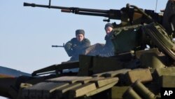  Russian-backed separatist sit on top a tank at the check-point north of Luhansk, Eastern Ukraine, Jan. 14, 2015.