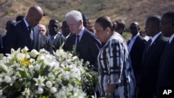 Presiden Haiti, Michel Martelly (kiri) dan mantan Presiden Bill Clinton menghadiri peringatan tiga tahun gempa dahsyat di kuburan massal korban gempa di Titanyen, Haiti (12/1). 