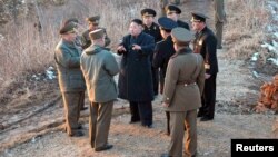 Pemimpin Korut, Kim Jong-Un (baju hitam, tengah) berbicara dengan para petinggi militer saat latihan perang Korea Utara (25/3). Sebagian besar warga Korsel menganggap Seoul tidak siap sepenuhnya untuk menanggapi aksi Korut. 