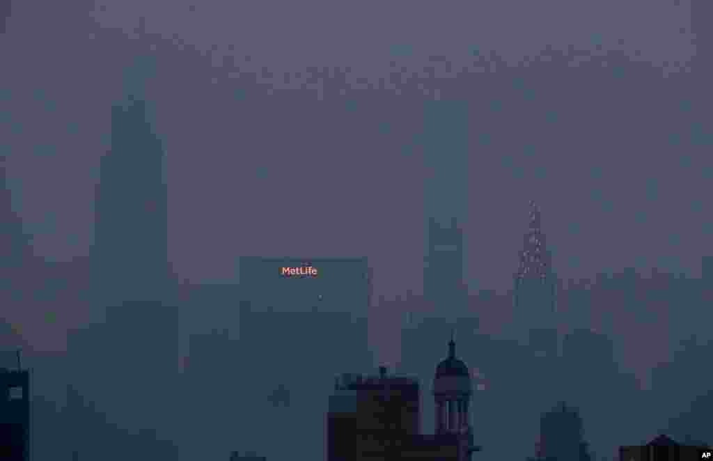 The Met Life and Chrysler buildings glow through a thick haze hanging over Manhattan in New York, July 20, 2021. Wildfires in the American West are creating hazy skies as far away as New York.
