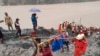 In this photo released from Myanmar Fire Service Department, rescuers carry a recovered body of a victim of a landslide from a jade mining area in Hpakant, Kachin state, northern Myanmar.