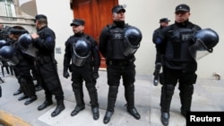 Policemen stand outside the entrance of former Argentine President and senator Cristina Fernandez de Kirchner’s home during a raid ordered by a judge in Buenos Aires, Argentina, Aug. 23, 2018. 