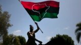 (FILE) Rein Morton waves a Pan-African flag on horseback during a Juneteenth celebration in Los Angeles, Friday, June 19, 2020.