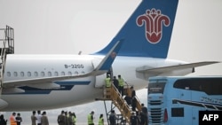 FILE - Alleged scam center workers and victims from China handed over from Myanmar board a plane at Mae Sot Airport in Mae Sot in Thailand's Tak province on Feb. 20, 2025.