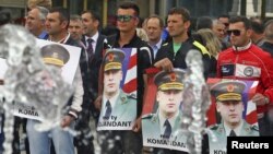 Protesters hold posters of Sylejman Selimi, a war commander during the 1998-1999 war, during a protest against a parliamentary vote to create a new war crimes court, in Pristina, Kosovo, May 29, 2015.