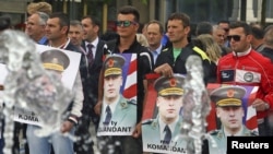 Protesters hold posters of Sylejman Selimi, a war commander during the 1998-1999 war, during a protest against a parliamentary vote to create a new war crimes court, in Pristina, Kosovo, May 29, 2015.