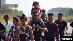 El migrante venezolano José Alberto Arteaga camina con su esposa mientras carga a su hija de 8 meses, en camino hacia la frontera de EEUU junto con otros migrantes, cerca de San Pedro Tapanatepec, México, el 13 de noviembre de 2022. REUTERS/José de Jesús Cortés
