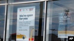 A sign in the window at a McDonald's restaurant states no dine-in seating May 7, 2020, in Oklahoma City, where three employees suffered gunshot wounds when a customer opened fire because she was angry that the restaurant's dining area was closed.