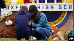 Los dolientes lloran en Oxford High School en Oxford, Michigan, el 1 de diciembre de 2021. Las autoridades dijeron que un estudiante de segundo año de 15 años abrió fuego en Oxford High School, matando a cuatro estudiantes e hiriendo a otras siete personas el martes. 