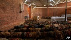 FILE—Victims' clothes who were slaughtered as they sought refuge inside and around the Catholic church cover the pews as a memorial to the thousands who were killed during the 1994 genocide, in Nyamata, Rwanda, April 5, 2024.