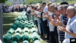 Bosnian Muslims pray in front of coffins during a reburial ceremony for dozens of newly identified victims of the 1995 massacre, at the memorial center of Potocari near Srebrenica, 150 km northeast of Sarajevo, Bosnia, July 11, 2017.