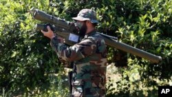 FILE - A Hezbollah fighter holds an Iranian-made anti-aircraft missile on the border with Israel, in Naqoura, south Lebanon, April 20, 2017. The British government will make inciting support for Hezbollah a criminal offense.