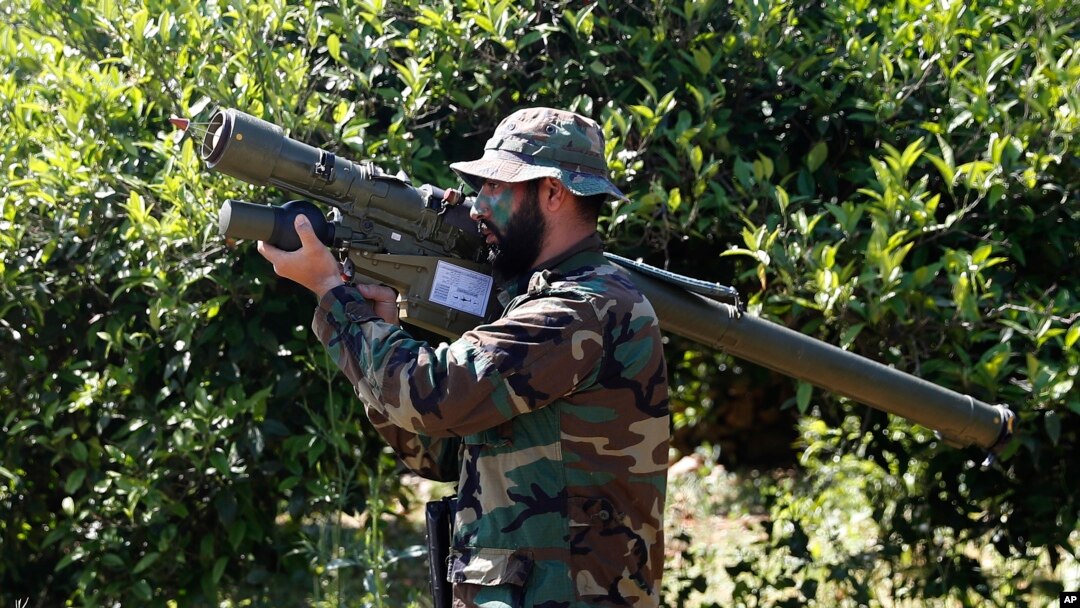 FILE - A Hezbollah fighter holds an Iranian-made anti-aircraft missile on the border with Israel, in Naqoura, south Lebanon, April 20, 2017. The British government will make inciting support for Hezbollah a criminal offense.