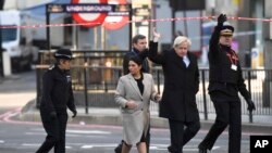 Britain's Prime Minister Boris Johnson, second right, and Home Secretary Priti Patel attend the scene at London Bridge in London, Nov. 30, 2019, after an attack on Friday. 