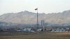 FILE - North Korea's flag flies on a tower high above the village of Ki Jong Dong, as seen from an observation post in Panmunjom, March 25, 2012.