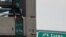 A pro-Palestinian demonstrator places a banner at the parking lot of Terminal 4 as security units await the arrival of an expected protest at the JFK International Airport in New York, Jan. 1, 2024. 