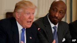 El presidente Donald Trump habla junto a Kenneth Frazier, director ejecutivo de Merck en febrero de este año. Frazier renuncio al consejo de empresas manufactureras de la Casa Blanca en protesta por la respuesta de Trump a la violencia en Charlottesville, Virginia.