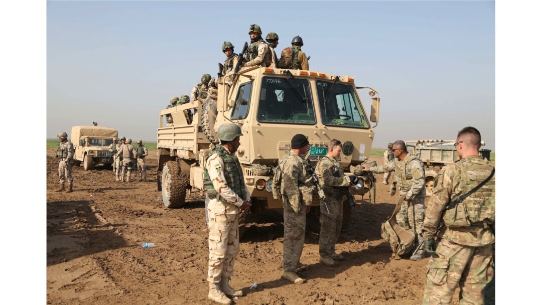 FILE - Iraqi soldiers participate in an exercise with American and Spanish trainers at Basmaya base, southeast of Baghdad, Iraq, Jan. 24, 2016.