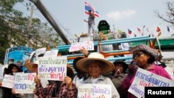 Petani membawa poster dalam sebuah protes meminta pemerintahan Yingluck segera membayar skema beras mereka di pinggiran Bangkok, 6 Februari 2014