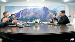 North Korean leader Kim Jong Un, second from right, talks with South Korean President Moon Jae-in, second from left, during a meeting at the border village of Panmunjom in Demilitarized Zone, April 27, 2018.