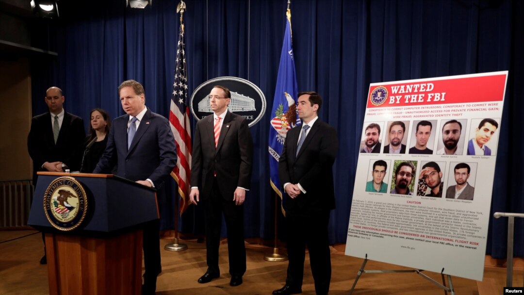 Wakil Jaksa Agung AS Rod Rosenstein bersama pejabat penegak hukum lainnya di Departemen Kehakiman mendengarkan Jaksa Geoffrey Berman untuk Distrik Selatan New York, memberikan pengumuman mengenai peretasan siber besar-besaran yang dilakukan oleh sembilan warga Iran, dalam konferensi pers di Washington, AS, Maret 23, 2018.