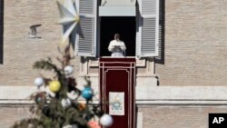 Paus Fransiskus menyampaikan pidatonya dalam doa Angelus dari jendela studionya yang menghadap ke Lapangan Santo Petrus di Vatikan, Minggu, 24 Desember 2017.