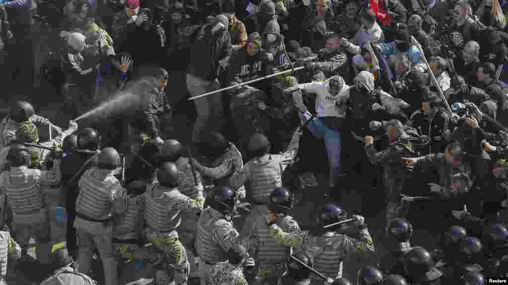 Protesters, right, clash with Interior Ministry and law enforcement members during a rally near the parliament building in Kyiv, Oct. 14, 2014. Thousands of Svoboda nationalist party supporters rallied in Kyiv earlier Tuesday in celebration of the Ukrainian Insurgent Army, but officials from the party denied vehemently that its members were involved in the unrest. 