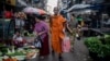 A Buddhist monk walks along a street market in Yangon on November 28, 2024. 