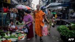 A Buddhist monk walks along a street market in Yangon on November 28, 2024. 