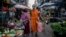 A Buddhist monk walks along a street market in Yangon on November 28, 2024. 