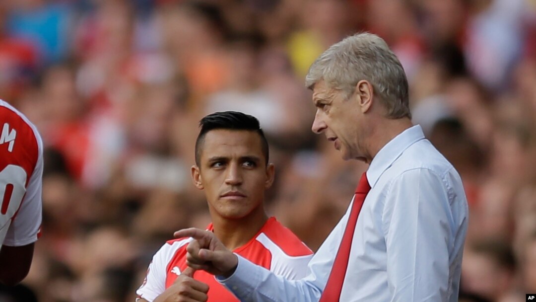 Manajer Arsenal, Arsene Wenger (kanan), memberi instruksi pada Alexis Sanchez dalam sebuah pertandingan melawan Benfica di London.