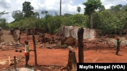 Des enfants se tiennent parmi les maisons brûlées lors d'une opération d'expulsion SODEFOR dans la forêt protégée de Goin-Débé, Côte-d'Ivoire. (2016 Human Rights Watch)