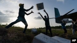 Haitian aid workers unload food from a VM-22 Osprey at Jeremie Airport, Aug. 28, 2021, in Jeremie, Haiti.