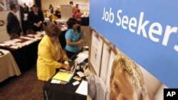 People walk by recruiters at a jobs fair in the Pittsburgh suburb of Green Tree, Pennsylvania, July 10, 2012.